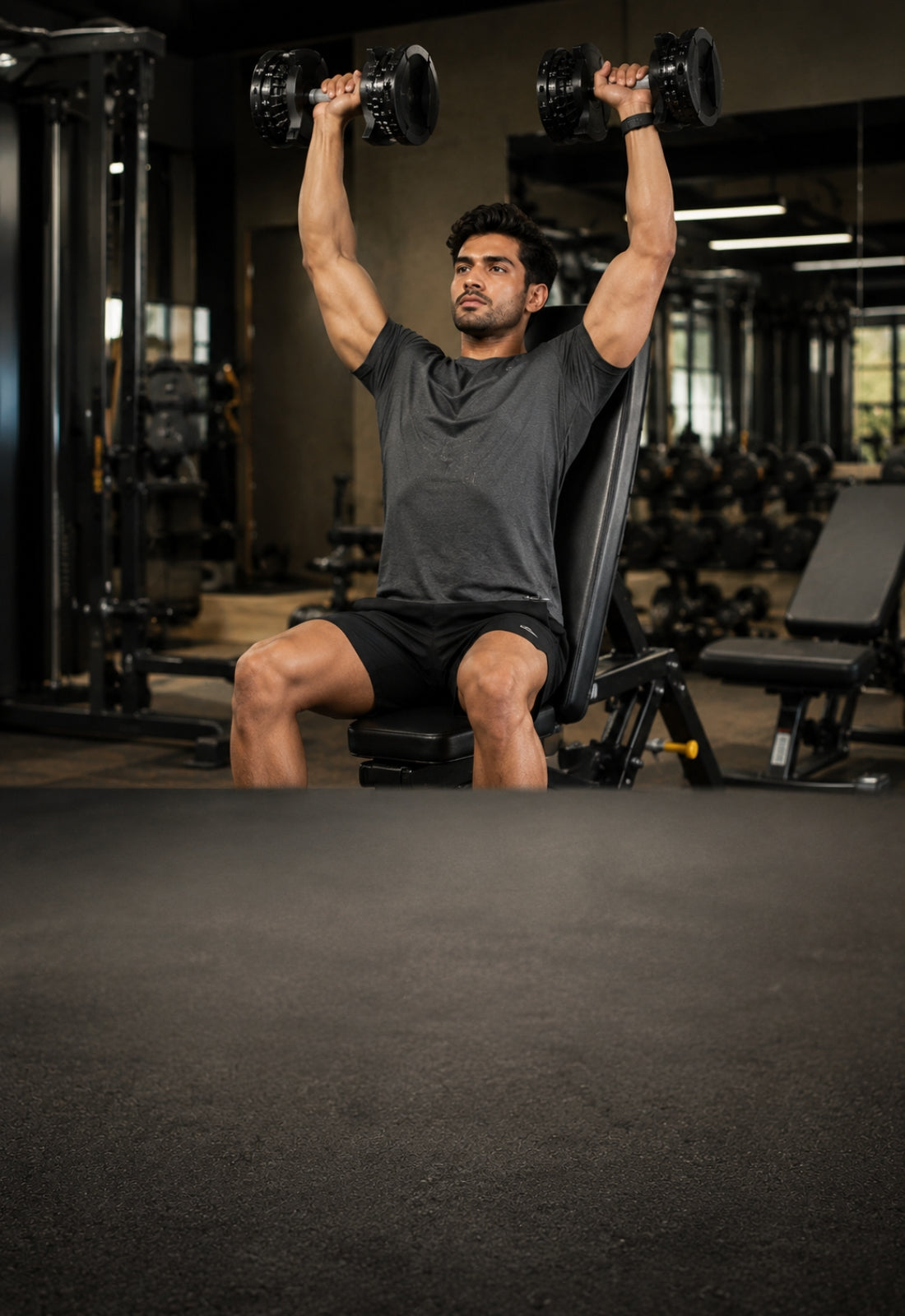 Man performing dumbbell shoulder press exercise in a gym setting